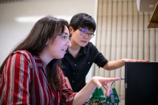 Electrical & Computer Engineering Professor Ruolin Zhou conducting research, with students, in the lab