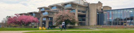 a student walking in front of the UMass Dartmouth library