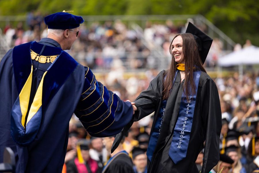 UMD graduate at commencement shaking Chancellor Fuller's hand