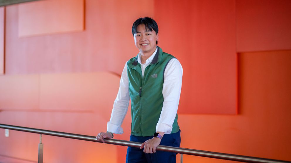 Kenny Duong '22, '23 standing in the Library
