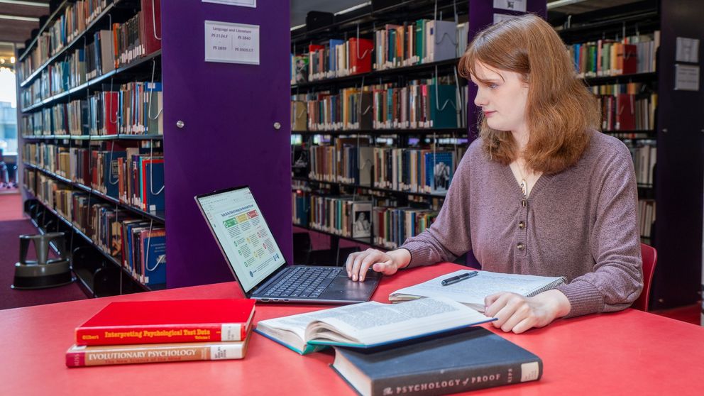 Student studying psychology books in the library