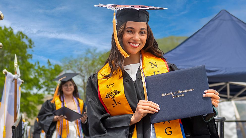 Nursing graduate holding their diploma