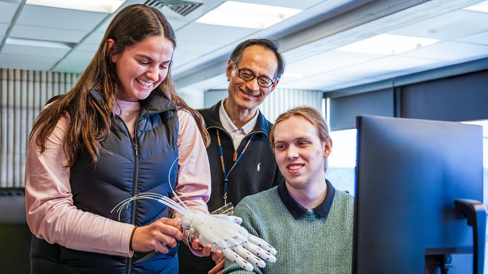 Bioengineering students in the lab working on a robotic hand prosthetic.