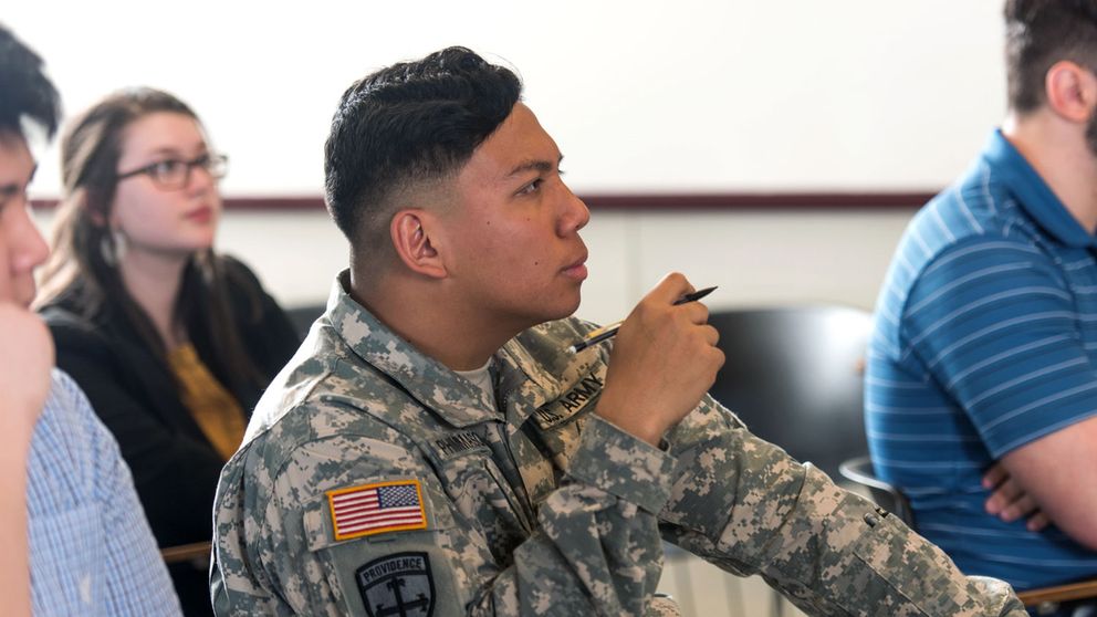 Student in army fatigues in a classroom