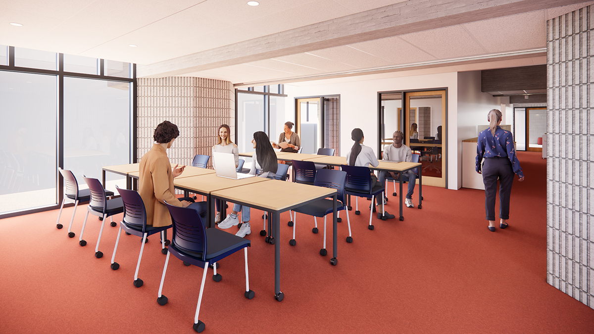 Students gathered around tables in a classroom with offices in the background